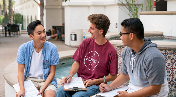 three students having a conversation outdoors